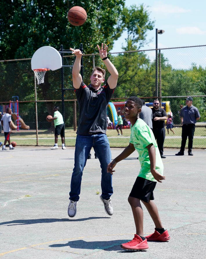 Bridgestone team member shooting hoops with student