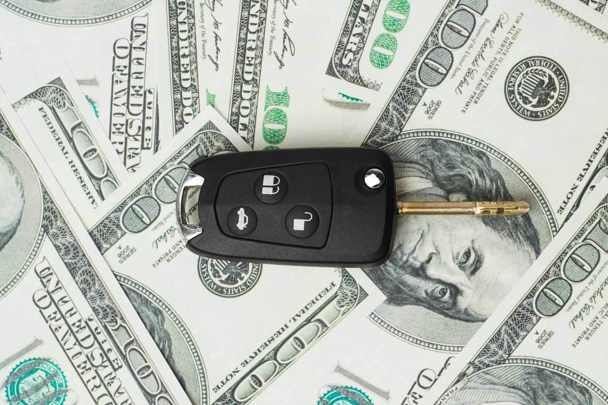 image of a car key laying on money