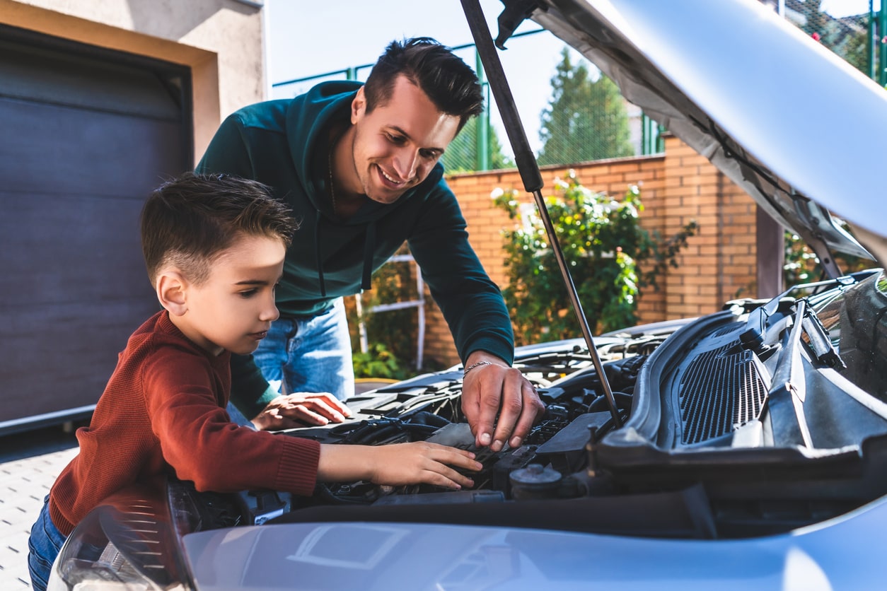 image of a father and son working on the car at home