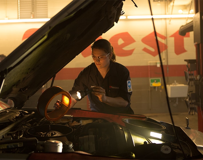 Female mechanic fixing car at repair shop
