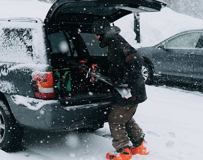 taking skis out of the trunk in the snow